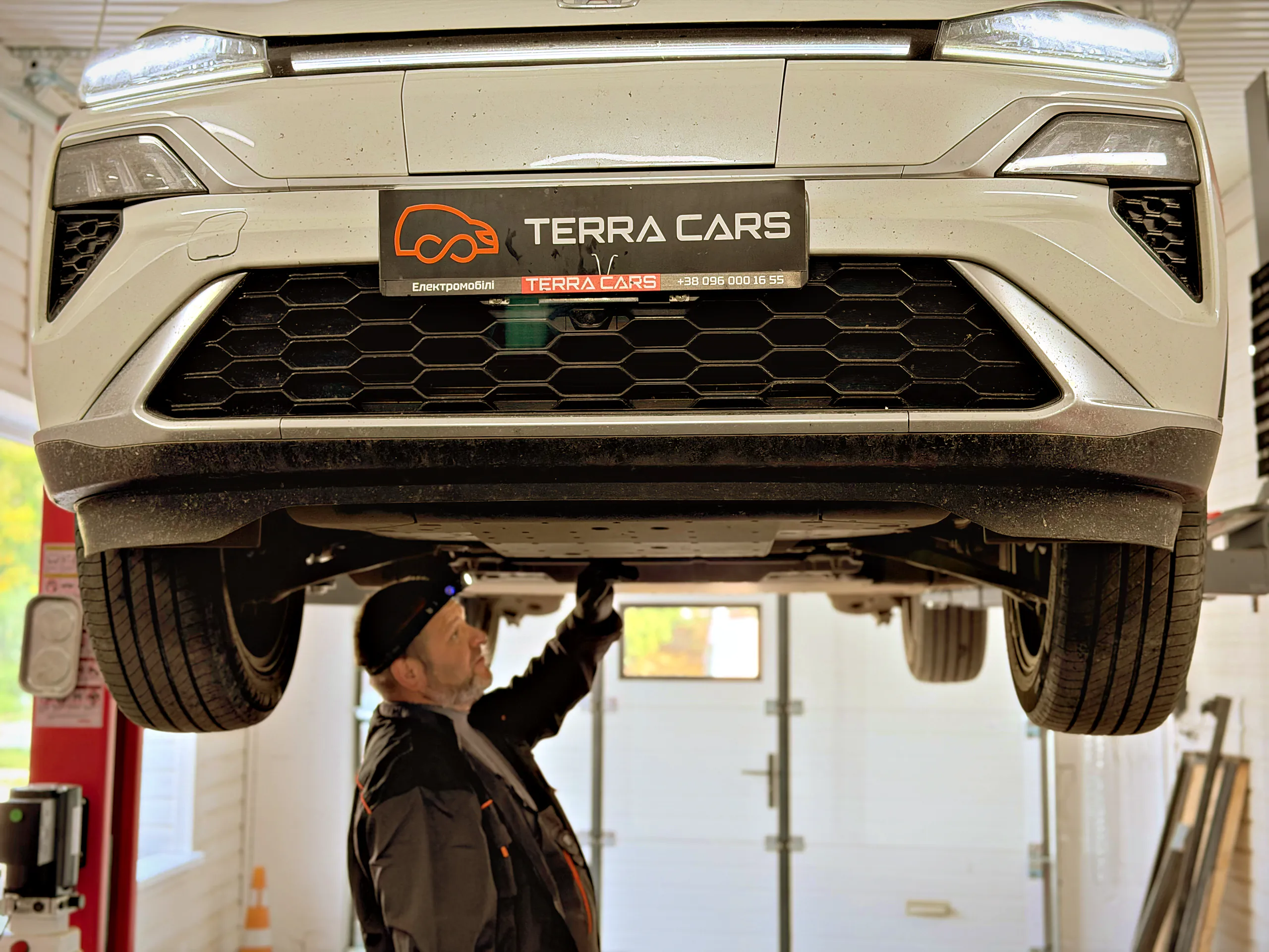Механік Terra Cars оглядає днище електромобіля на підйомнику